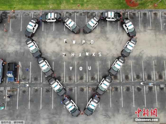 近日,美国迈尔斯堡警察在一所医院大楼前用警车拼成“爱心”形状致谢医护人员。 美国确诊病例已近百万例 世卫称新冠大流行远未结束